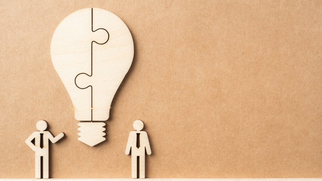 Two individuals with a graphic of bulb discussing hidden potential of Customer Insights